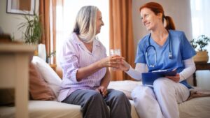 Nurse consulting with senior woman her health condition and taking pills, at her appartment.