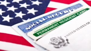 United States of America social security and green card with US flag on the background. Immigration concept. Closeup with shallow depth of field.