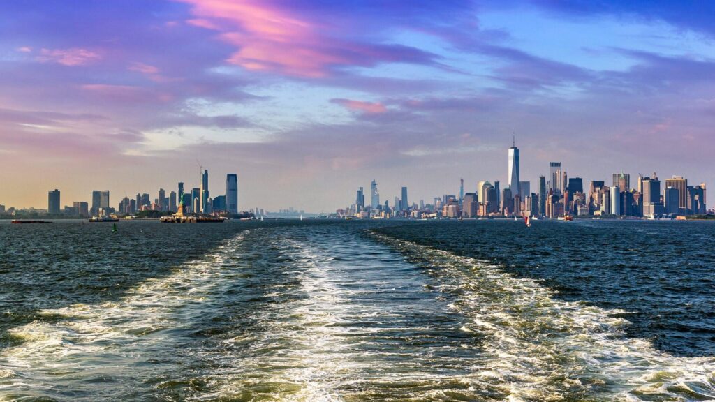 Cruise wash foam in Hudson river and Panoramic view of Statue of Liberty and Manhattan and Jersey city  in New York City, NY, USA